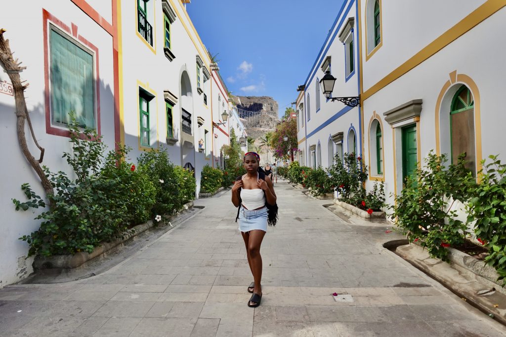 Young woman walking through streets of Puerto Mogan.