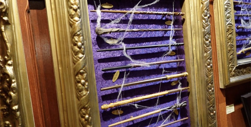 Wands of different Harry Potter characters inside a golden picture frame.