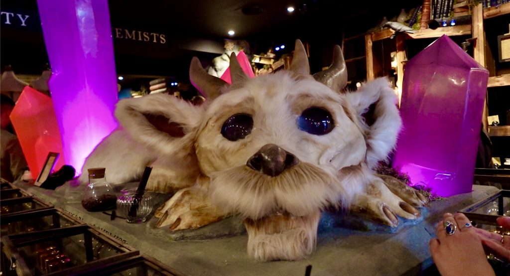 A fake, stuffed dragon with plastic crystals surrounding it.