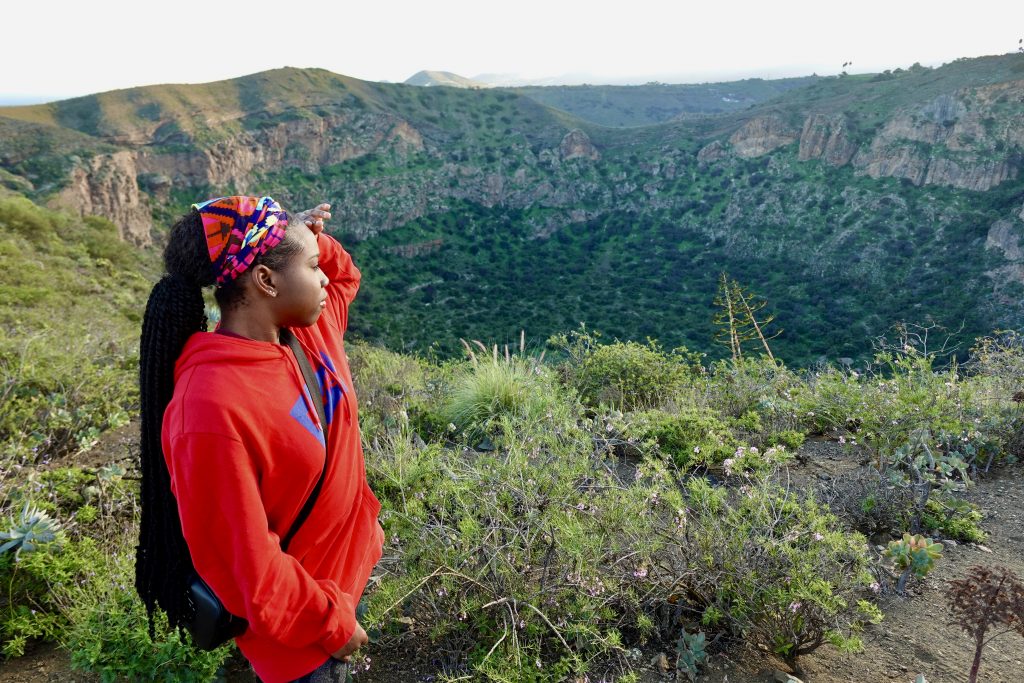 Young woman looking at the crater of Caldera de Bandama. 