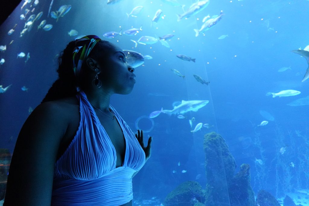 Young woman looking up at aquarium.
