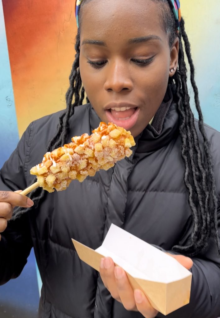 A person eating a corndog