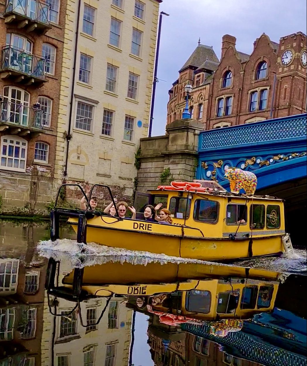 People on a yellow boat waving